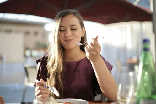 Junger Mensch bei einer gastronomischen Besichtigung. Frau beim Essen auf einer gastronomischen Besichtigung.