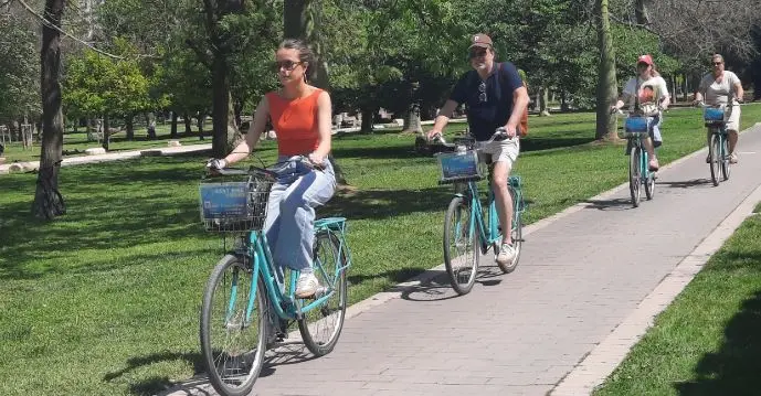 Touristen mit dem Fahrrad unterwegs im Turia-Garten in Valencia.