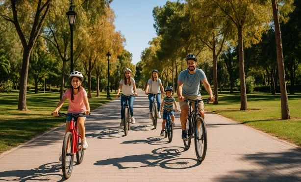 Familie fährt mit dem Fahrrad durch den Jardín del Turia in Valencia