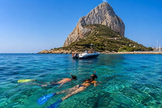 Zwei Touristen beim Schnorcheln am Peñón de Ifach in Calpe.