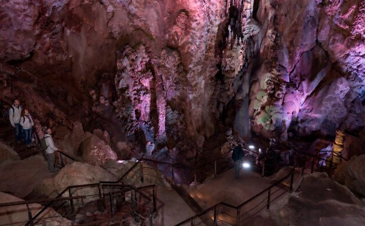 Innenansicht der Cuevas de Canelobre bei Busot mit beleuchteten Felsformationen, Stalaktiten und Besuchern auf dem Rundweg.